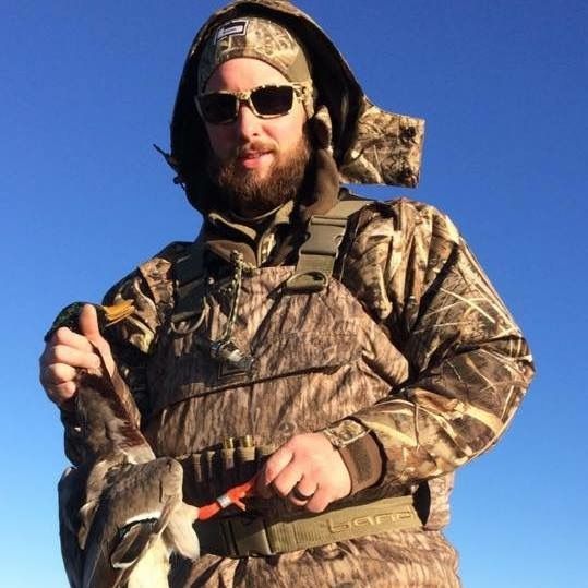 man posing with shot duck