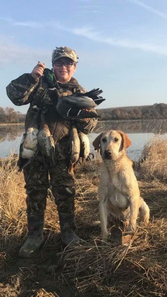person posing with killed ducks and dog