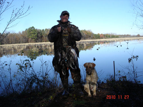 man and dog posing in bird hunting ground